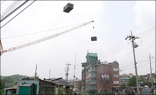 경찰특공대를 태운 컨테이너 2개가 대형 크레인에 매달려 건물로 이동하고 있다. 